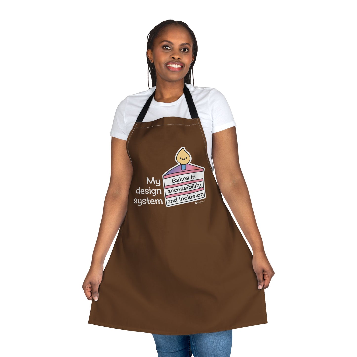 A person wearing a brown apron that features the words “My design system” alongside a vibrant 3-tier cake graphic that reads “Bakes in accessibility and inclusion.”
